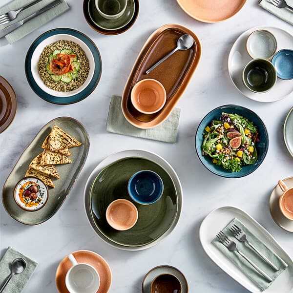 A table with Acopa Highlands blue china bowls filled with food.