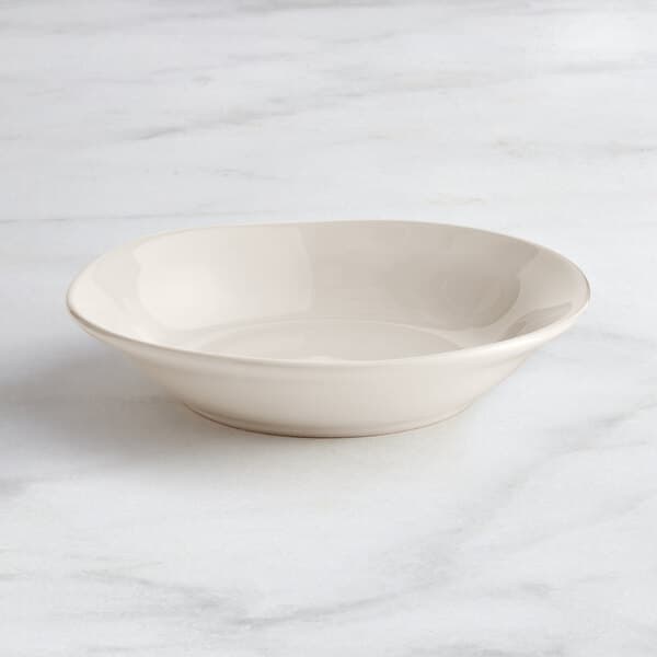 An Acopa Highlands white china bowl on a marble surface.