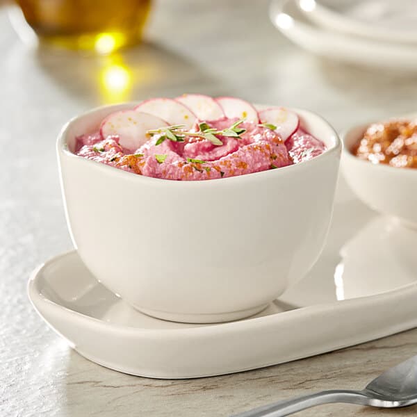 A white Acopa Highlands bouillon cup filled with pink food on a table.