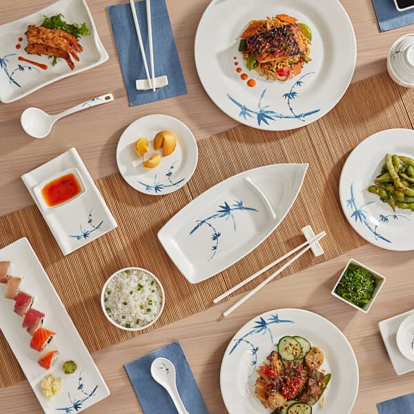 A white plastic Acopa soup ladle on a table with bowls of food.