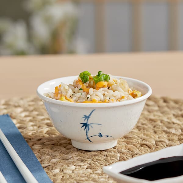 A bowl of rice with vegetables and sauce in an Acopa Biru melamine rice bowl with chopsticks.