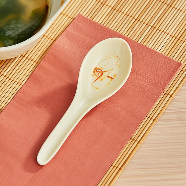 An Acopa Brassia melamine wonton soup spoon on a napkin.