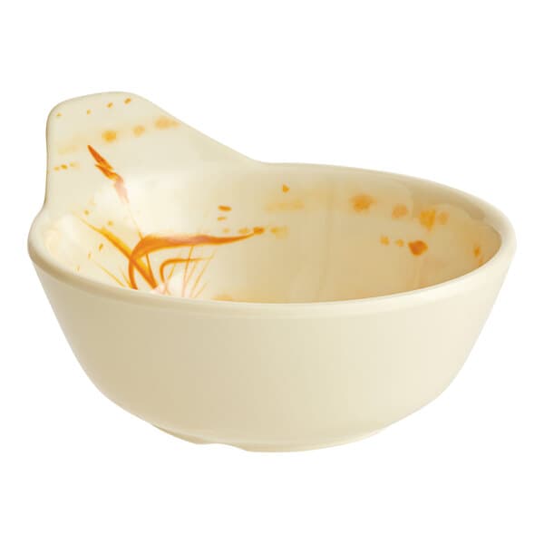 A beige bowl with gold splatter designs.
