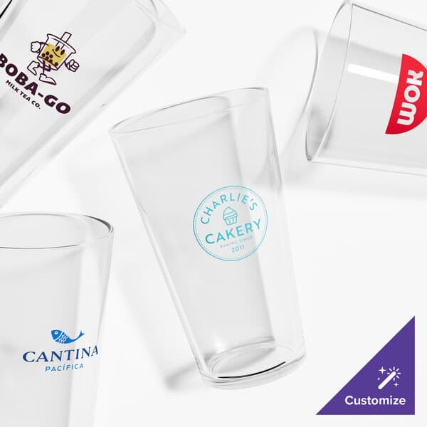 A close-up of an Acopa mixing glass with a custom logo.