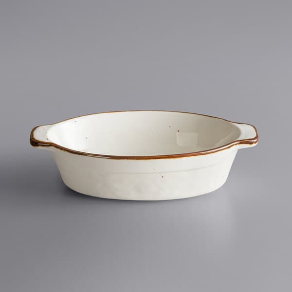 A white porcelain oval casserole dish with a brown rim.