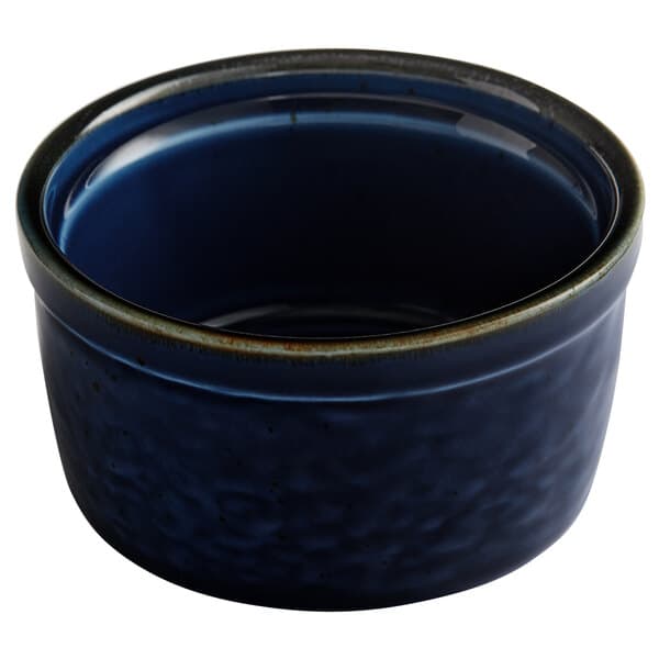 An Acopa Keystone Azora Blue porcelain ramekin with a rim on a table.