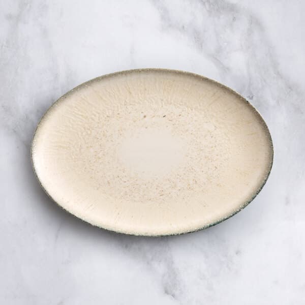 An Acopa Cape oval gray porcelain platter with a brown speckled surface.