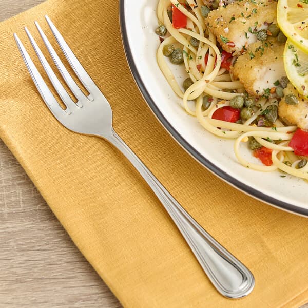 A plate of food with an Acopa Edgeworth stainless steel dinner fork on it.