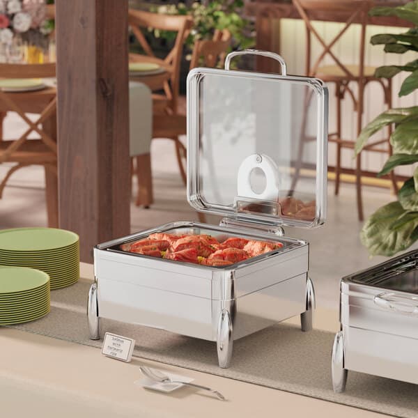 A table with two Acopa Manchester 2/3 size square chafers on stands with fuel holders.