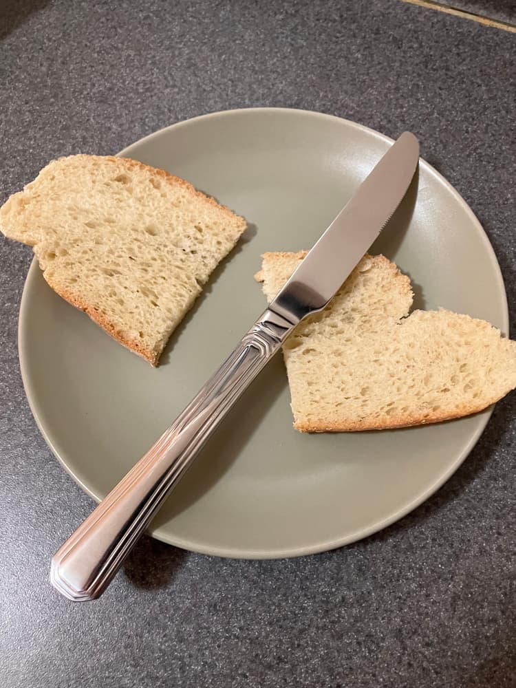 Acopa 9 1/4" knife. The picture shows the mirror finish, and its effectiveness at cutting a slice of bread.
