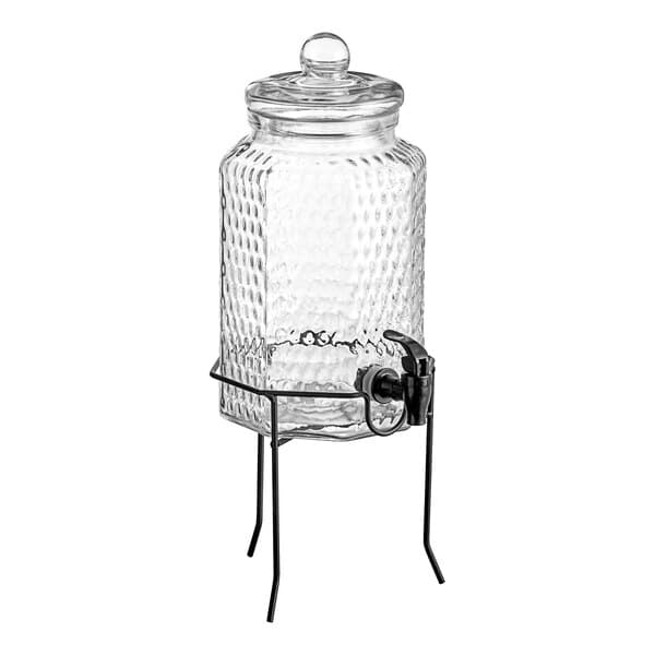 An Acopa glass beverage dispenser with a metal stand and tap.