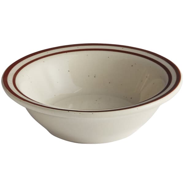 A white stoneware monkey dish with a brown speckled rim.
