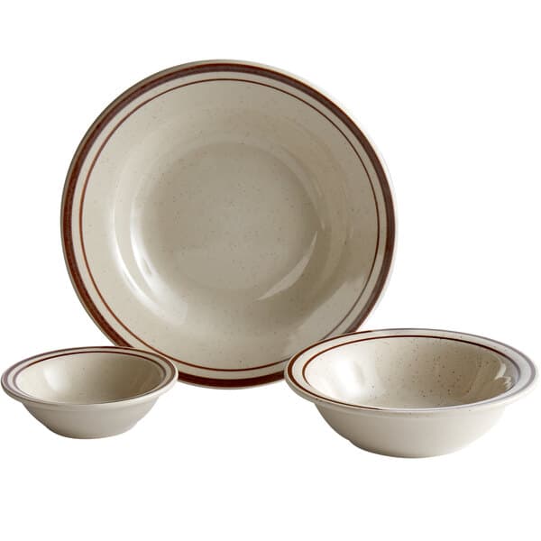 An Acopa narrow rim stoneware bowl with brown speckles.