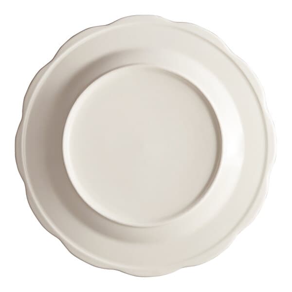 An ivory Acopa stoneware plate with a scalloped edge.