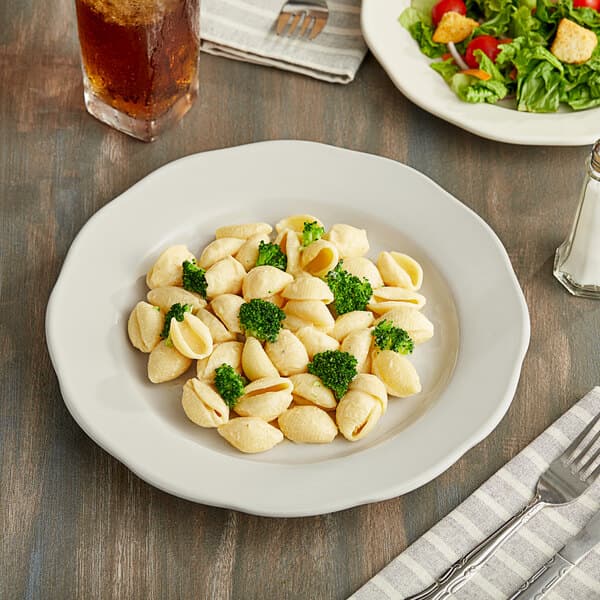 A plate of pasta and salad on an Acopa ivory stoneware plate.