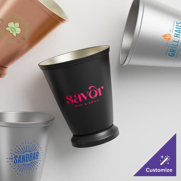 A group of Acopa stainless steel mint julep cups with beaded detailing on a counter.