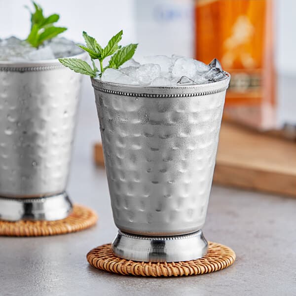 Two silver Acopa Alchemy mint julep cups with ice and mint leaves.