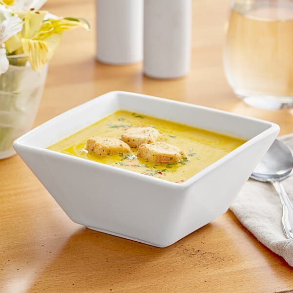 A bowl of soup with a spoon in it on a table.