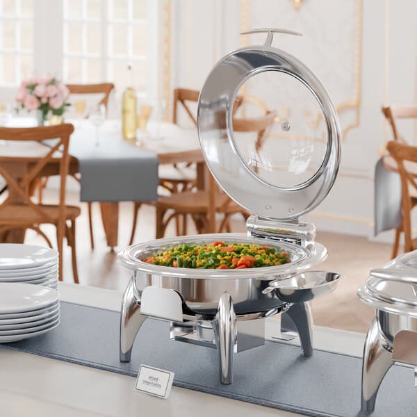 A buffet table with an Acopa Voyage chafing dish holding food.