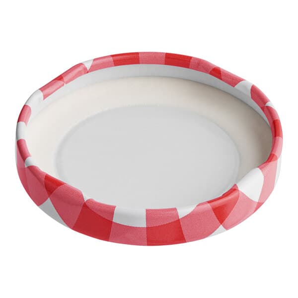 A white plate with a red and white checkered Acopa milk bottle lid.