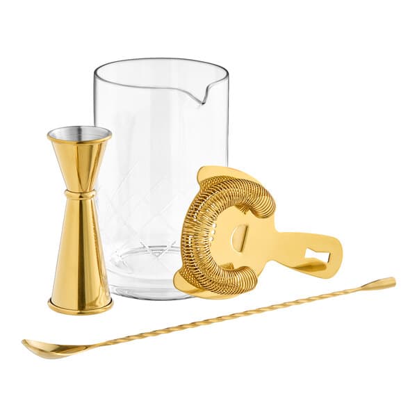 An Acopa gold cocktail stirring set with a glass and spoon.