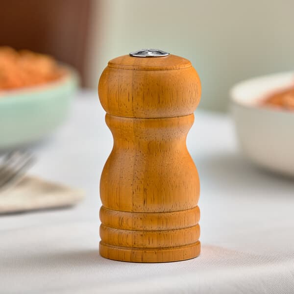 An Acopa wooden salt shaker on a table.