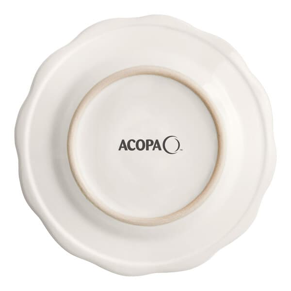 An ivory Acopa stoneware plate with a scalloped edge and circular ring.