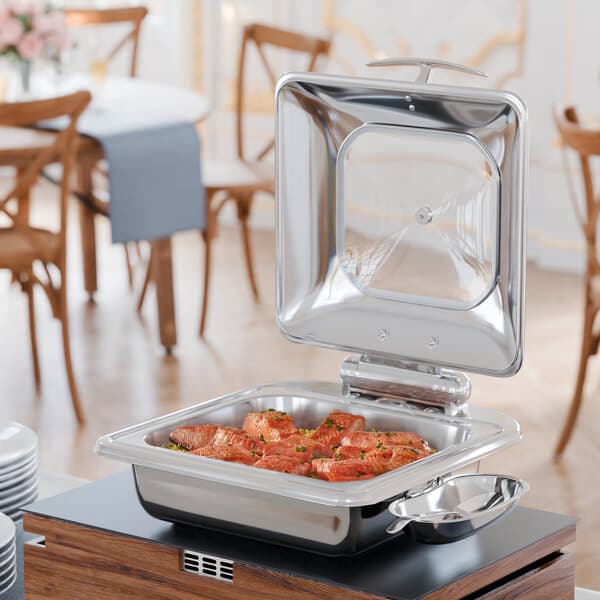 An Acopa stainless steel chafer with food inside on a table.