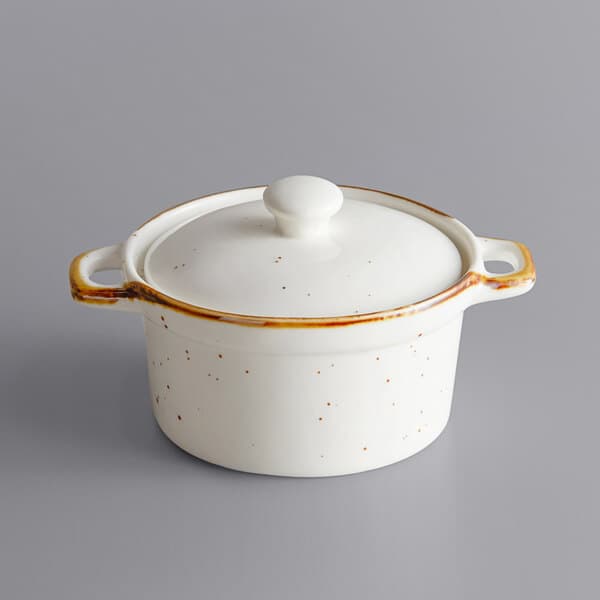 An Acopa Keystone vanilla bean stoneware mini casserole dish with a white lid.