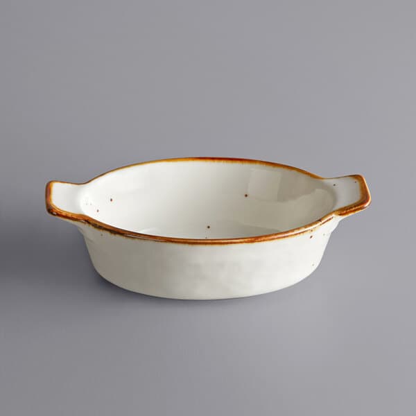 A white stoneware rarebit dish with a brown rim.