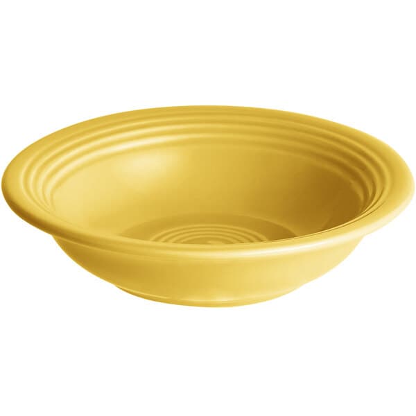 A yellow stoneware bowl with ripples on the rim.
