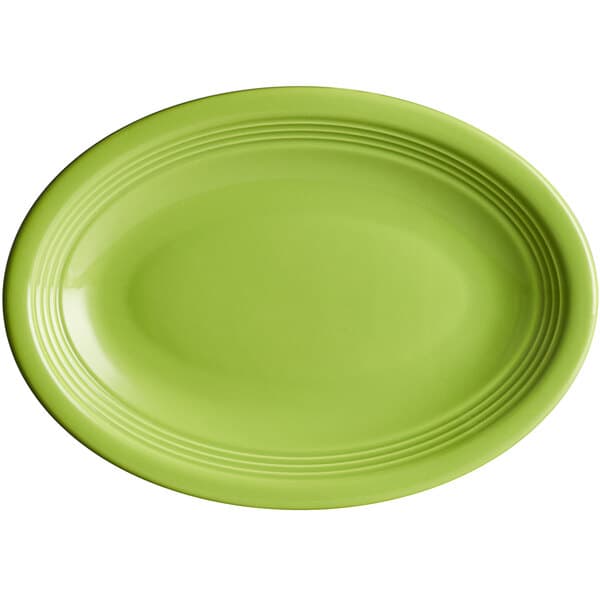 An Acopa Capri green oval stoneware coupe platter with a white border.