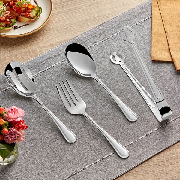 An Acopa Edgeworth stainless steel fork and spoon on a table with food.