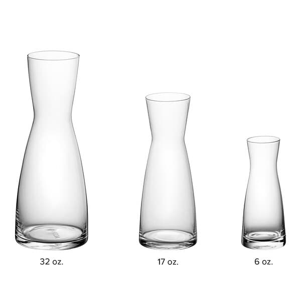 A group of Acopa glass carafes with different sizes.