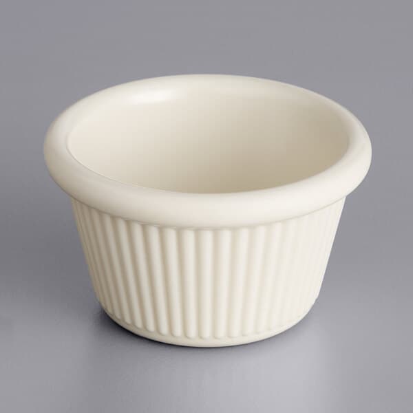A white Acopa fluted ramekin on a gray surface.