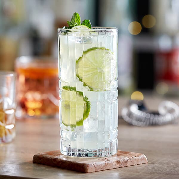 A close-up of an Acopa Madras highball glass of water with lime and mint.