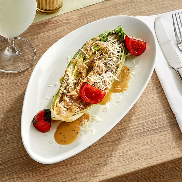 A white Acopa Nova triangle stoneware plate with food on it.