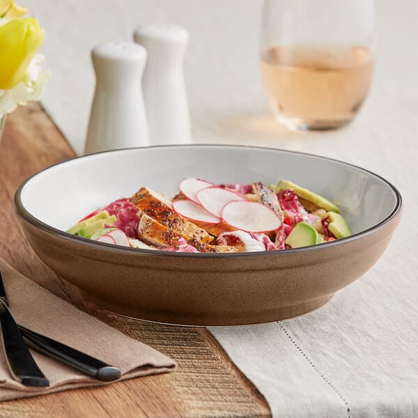 A brown Acopa Embers stoneware pasta bowl filled with food on a table.