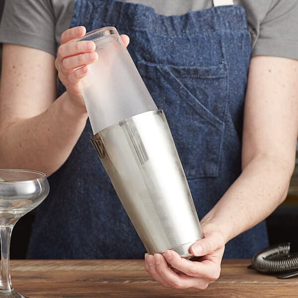 A woman using an Acopa stainless steel cocktail shaker.