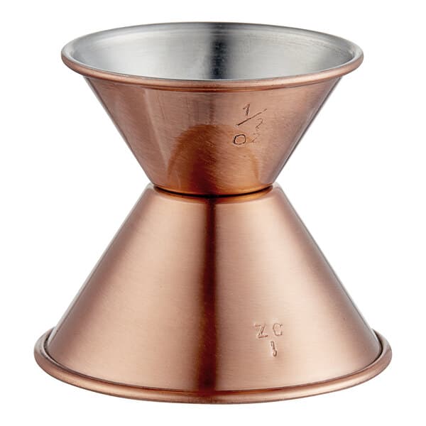 An Acopa copper jigger with a stainless steel base on a table.