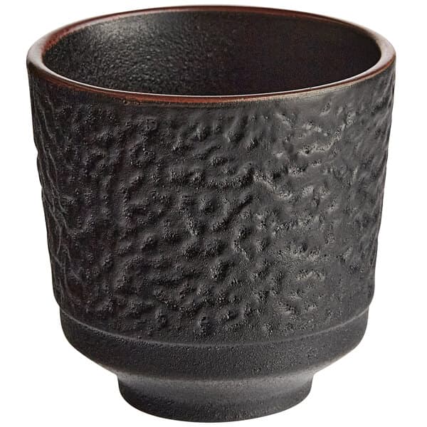 A black Acopa stoneware tea cup with a textured surface.