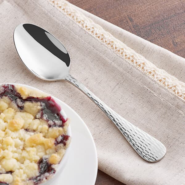 An Acopa Inspira stainless steel oval bowl dessert spoon with blueberry pie on it.