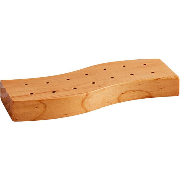 A close-up of a dark brown wooden Acopa Mesa skewer holder with holes in it.