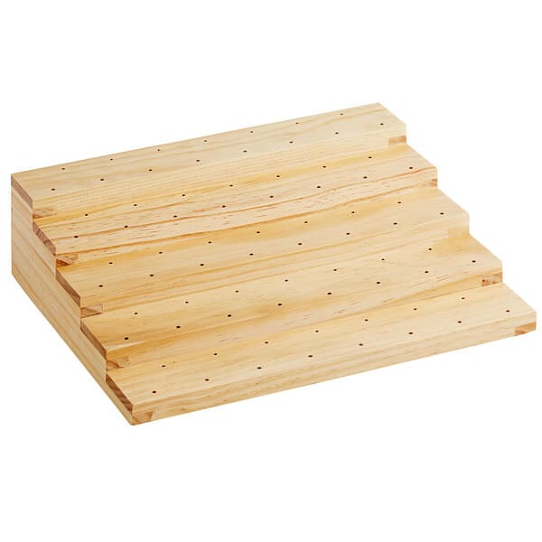 A natural wood board with holes in it on a table.