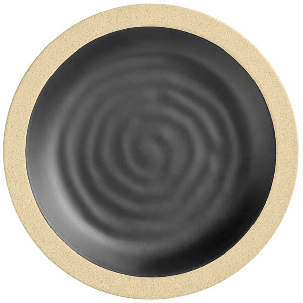 An Acopa Ugoki matte black melamine plate with a medium ivory rim with a spiral design.