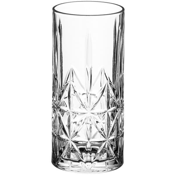 A close-up of an Acopa Gardenia clear beverage glass with a star pattern.