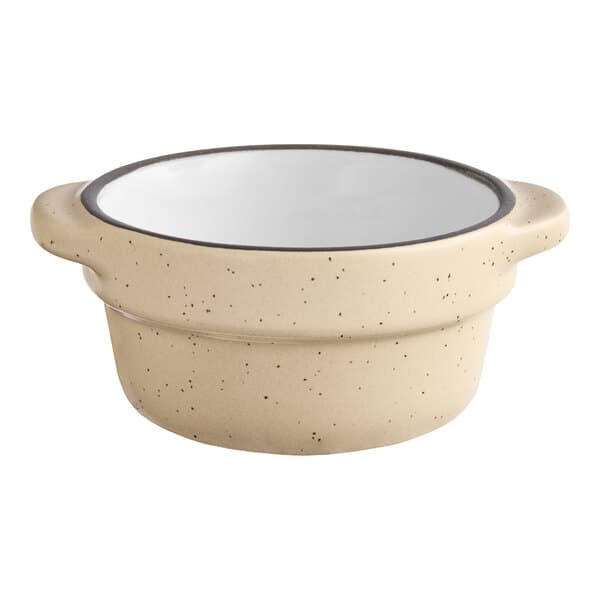 An Acopa Harvest Tan stoneware sauce cup with a black rim.