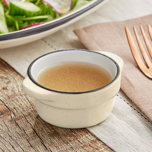 An Acopa Embers stoneware sauce cup filled with brown liquid.