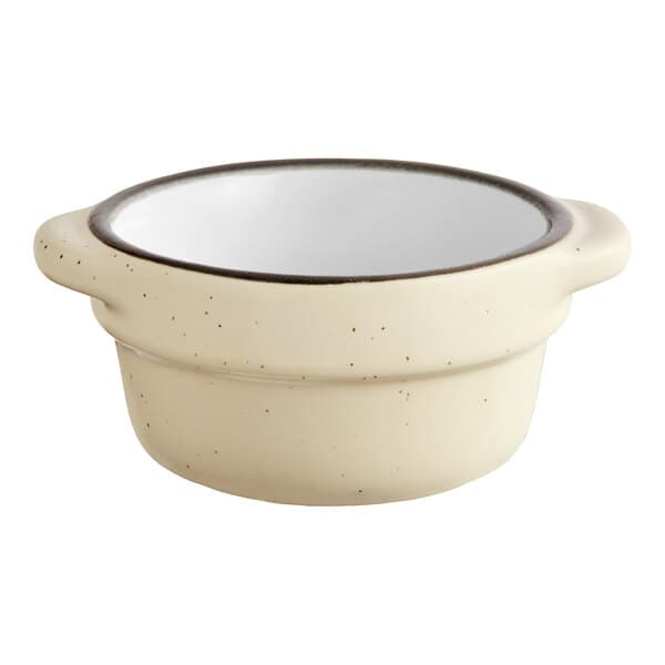A white stoneware sauce cup with a black rim.