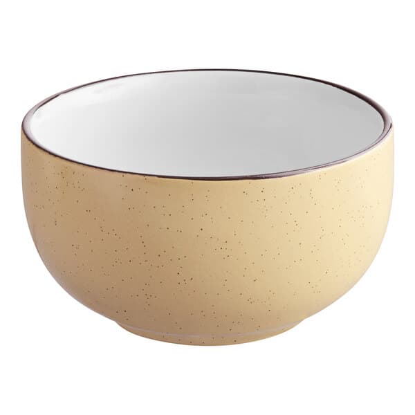 An Acopa Harvest Tan stoneware bowl with speckled surface and black rim.